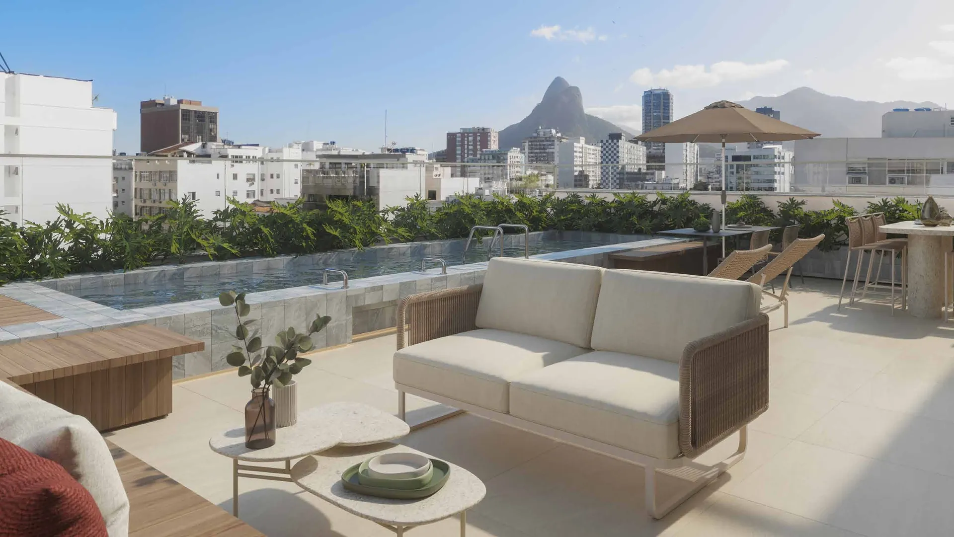 Lounge descoberto no rooftop com sofá e vista para o Morro Dois Irmãos