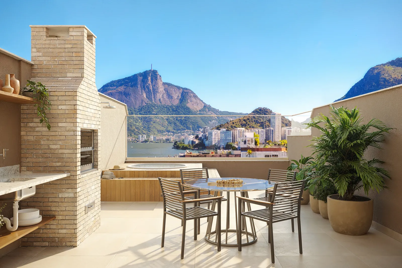 Terraço da cobertura com churrasqueira, mesa e vista para o Cristo
