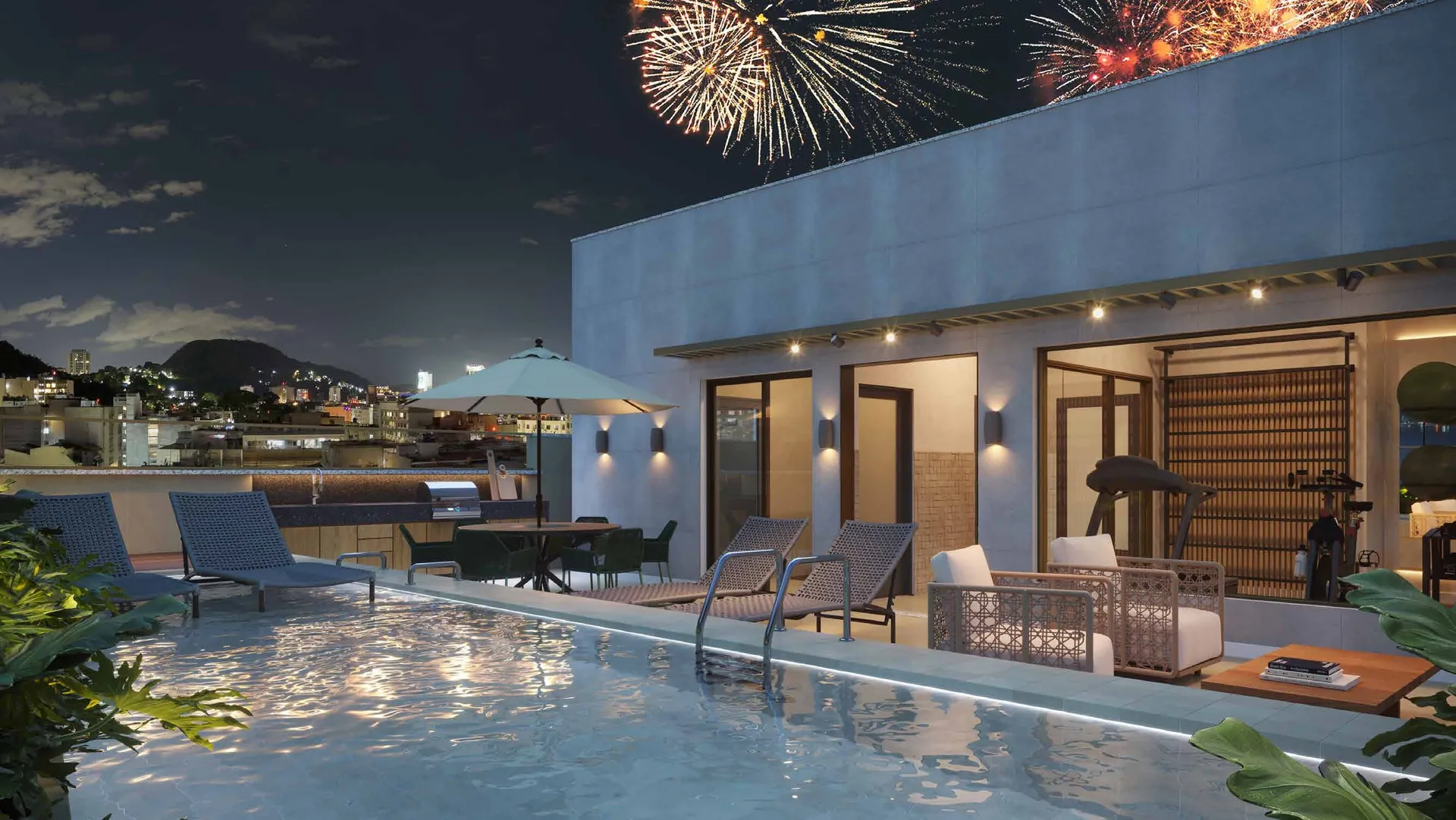 Piscina iluminada no rooftop com fogos no céu