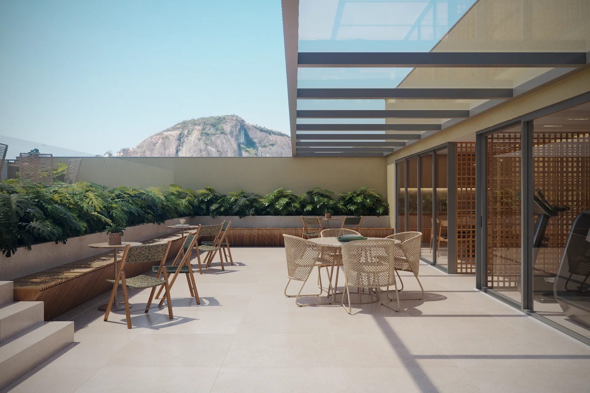 Terraço gourmet descoberto no rooftop, com mesas e o morro ao fundo