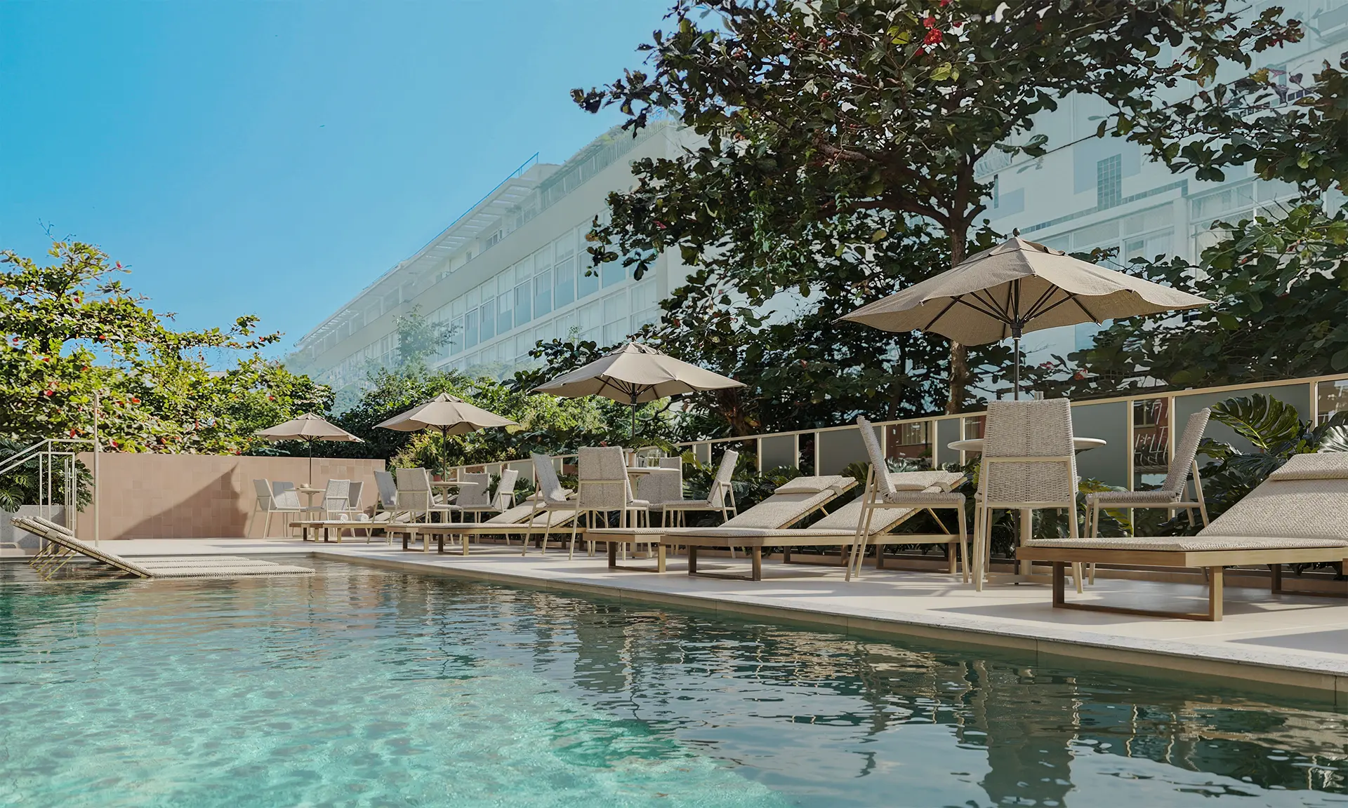Piscina no rooftop com espreguiçadeiras, jardineiras e o morro ao fundo