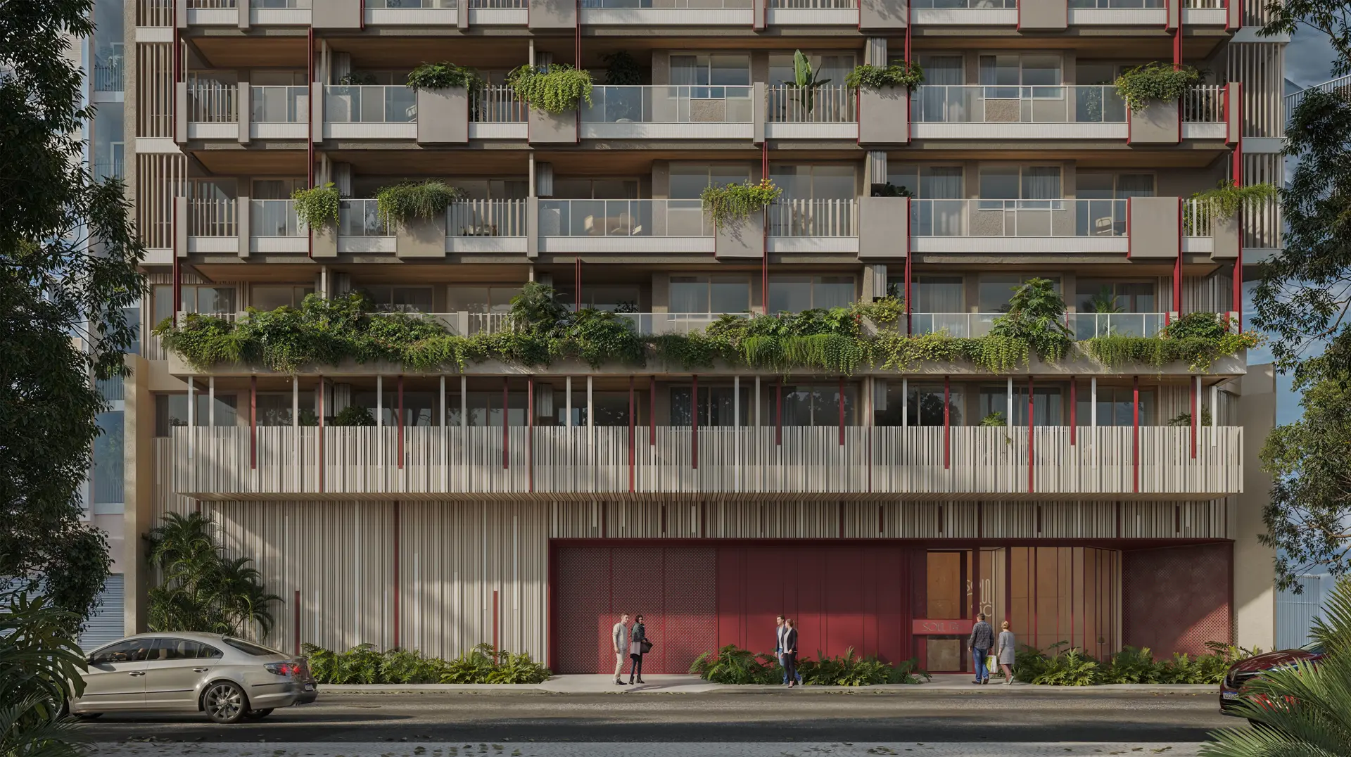 O térreo do prédio, com jardins, acesso de pedestres e portões vermelhos